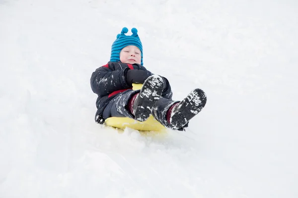 Little boy goes to the snowy hills on sleds — Stock Photo, Image