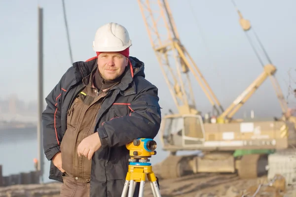 Engineer at the construction site makes measurements with leveli Stock Picture