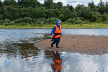Küçük çocuk kum üzerinde çalışan bir yeleği