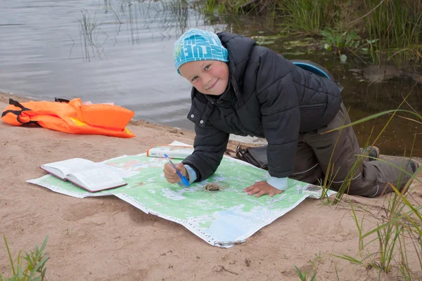 The boy is studying map of the area. Stock Picture