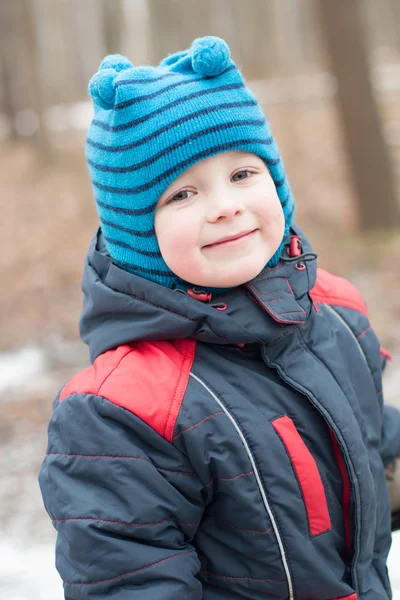 Small boy smiling on a walk in a winter park — Stock Photo, Image