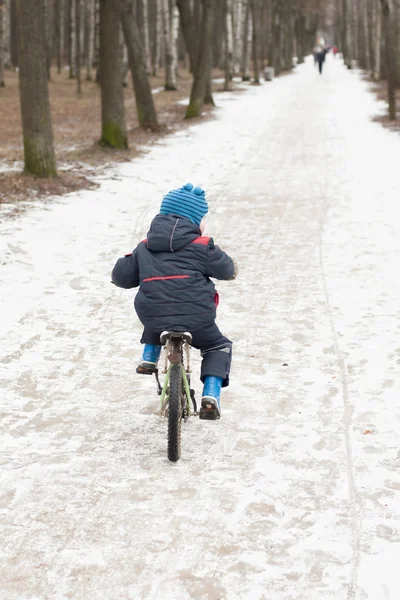 Petit garçon en vélo dans un parc en hiver — Photo