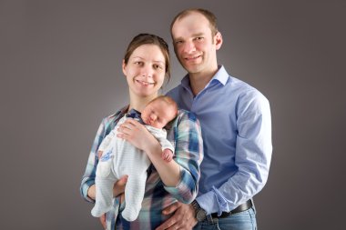 Anne ve baba yeni doğmuş bebeklerini kucaklıyorlar.