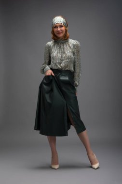 Gri üzerine izole edilmiş, modaya uygun, yaşlı bir kadının tam boy portresi.