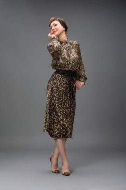 Gri üzerine izole edilmiş, modaya uygun, yaşlı bir kadının tam boy portresi.