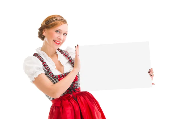 Bavorské žena v dirndlu, drží prázdná tabulka. — Stock fotografie