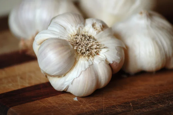 Tahta kesim tahtasında taze sarımsak karanfili. Tatları, yemekleri, aşçılık sanatlarını sembolize eder..