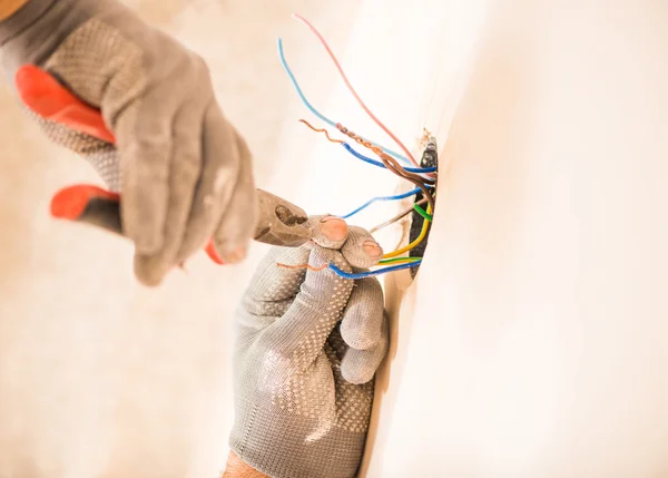 Человек, работающий с электрическими проводами — стоковое фото