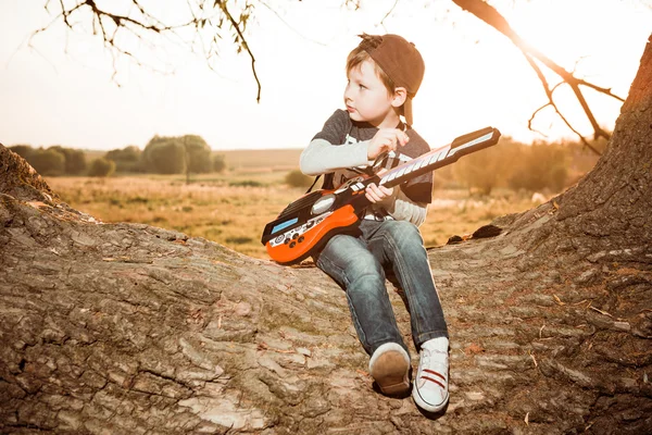 Menino tocando guitarra de plástico — Fotografia de Stock