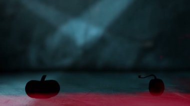 Ahşap arka planda renkli dumana bulanmış iki dönen balkabağı.