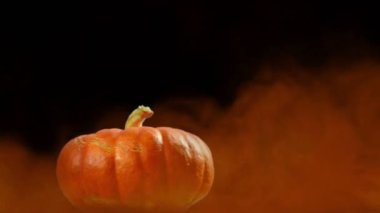 Siyah arka planda dumanla kaplı korkunç yüzüyle dönen balkabağı