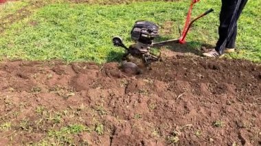 Çiftçinin bahar mevsiminde tarım makinesiyle toprağı sürmesi