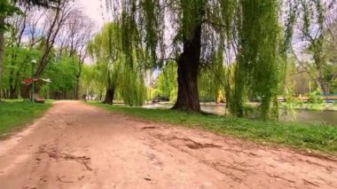 İlkbaharda gölet kenarlı Cyty Park yolu