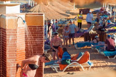 Mısır, Sharm el-Sheikh - 16.06.2021 turist tatil köyünde kızıl denizde yüzdükten sonra plaj banyosu yapıyor.