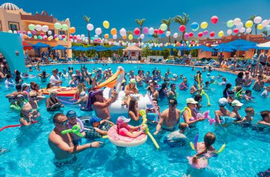 Mısır, Sharm el-Sheikh - 15.06.2021 Dansçı köpüklü otel partisi ve yüzme havuzunda eğlenen insanlar