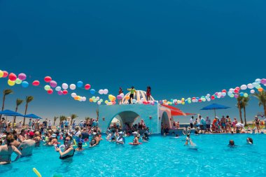 Mısır, Sharm el-Sheikh - 15.06.2021 Dansçı köpüklü otel partisi ve yüzme havuzunda eğlenen insanlar