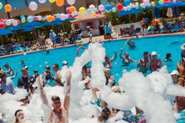 Mısır, Sharm el-Sheikh - 15.06.2021 Dansçı köpüklü otel partisi ve yüzme havuzunda eğlenen insanlar