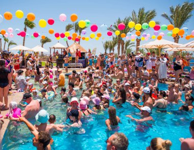 Mısır, Sharm el-Sheikh - 15.06.2021 Dansçı köpüklü otel partisi ve yüzme havuzunda eğlenen insanlar