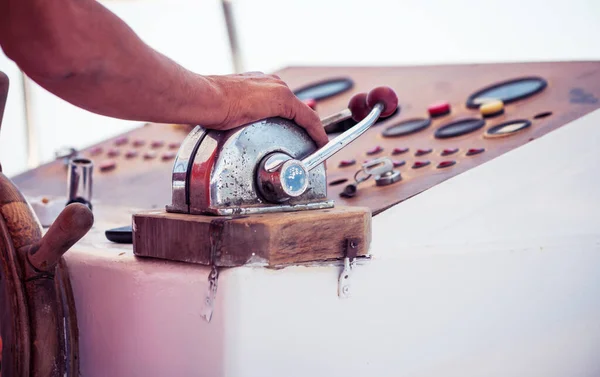 vintage control panel of motor boat with man hand on wheel