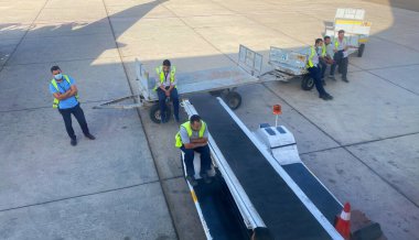 Mısır, Sharm el-Sheikh - 12.06.2021 havaalanı çalışanı nakil için turistlerin bagajlarını bekliyor