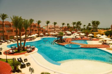 Mısır, Sharm el-Sheikh - 13.06.2021 ana yüzme havuzu otel blokları ve arka planda bungalov ile
