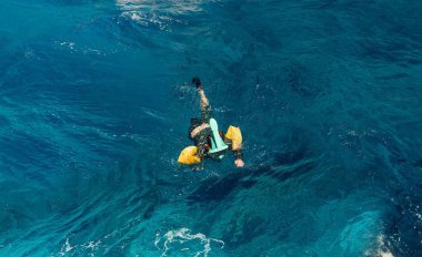 Dalış maskeli çocuk açık denizde yüzüyor. 