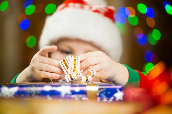 Junge im Ferienhut hält Geschenkband mit Fingern — Stockfoto