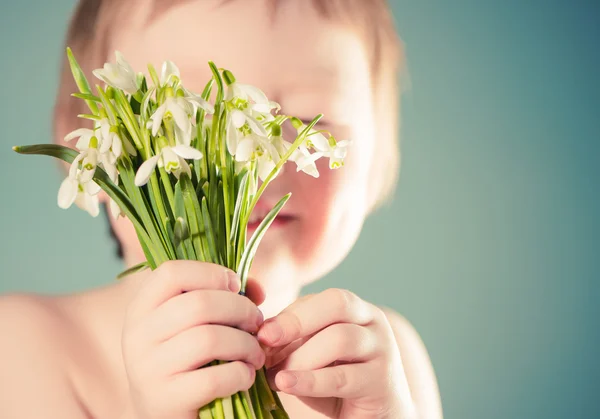 Menino segurando flores primavera — Fotografia de Stock