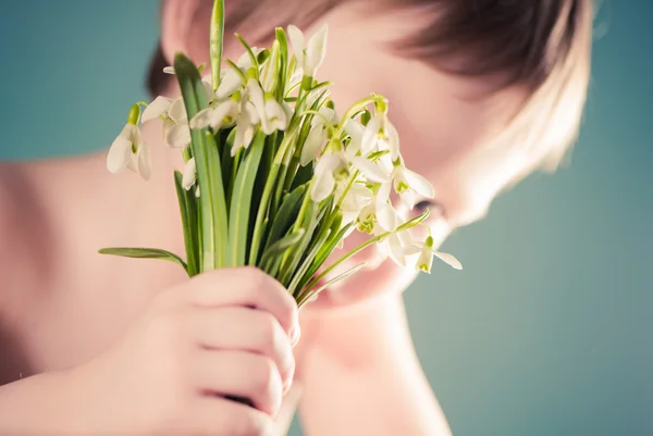 Menino segurando flores primavera — Fotografia de Stock