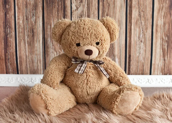 Teddy urso sentado no fundo de madeira — Fotografia de Stock