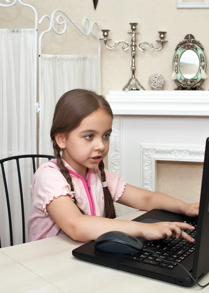 เด็กผู้หญิงเขียนในคอมพิวเตอร์ที่บ้าน — ภาพถ่ายสต็อก