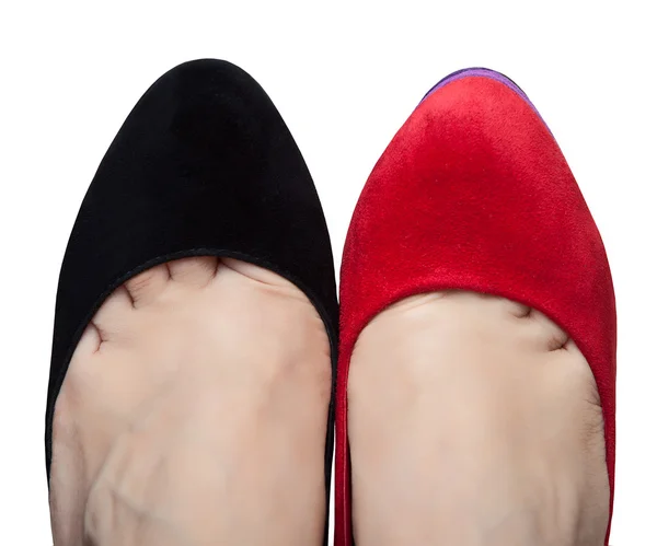 Een paar van vrouwelijke benen in schoenen met verschillende kleuren — Stockfoto