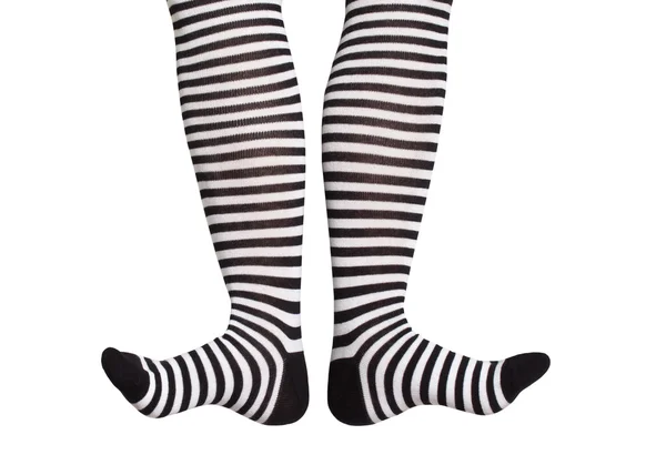 Füße in schwarz-weiß gestreiften Socken — Stockfoto