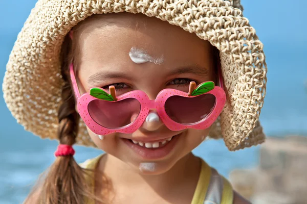 Happy kid with glasses on the nose with sunscreen on your face — Stock Photo, Image