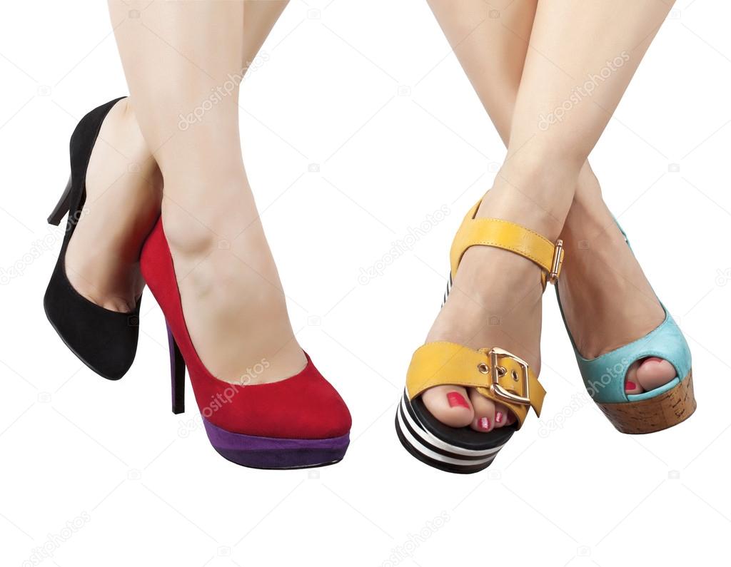 Two pairs female feet in different shoes and sandals