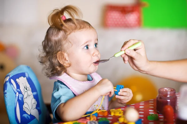 Alimentando o bebê com uma colher em casa — Fotografia de Stock