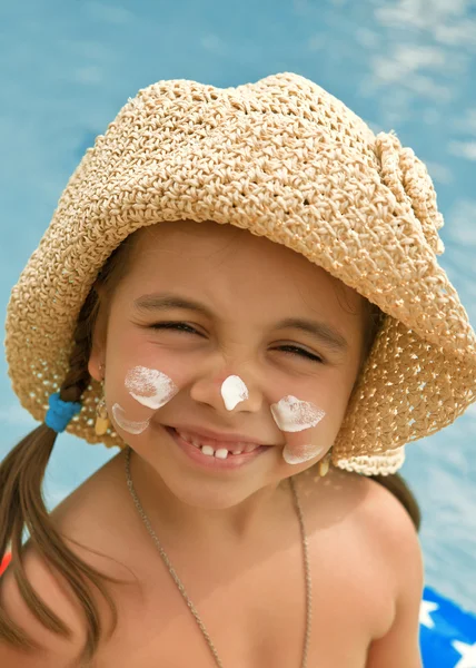 Boldog gyermek fényvédő a face, a háttérben a víz — Stock Fotó