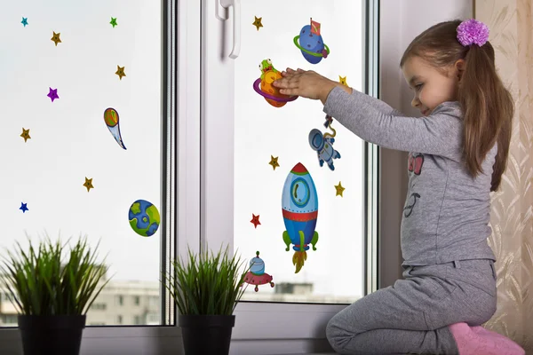 Girl decorates the window in the children's room. style space — Stock Photo, Image