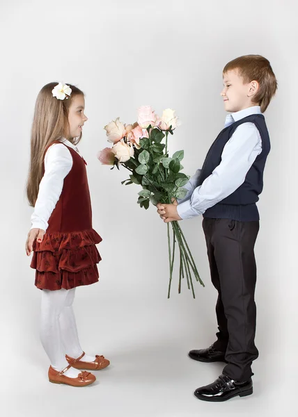 De jongen geeft het meisje een boeket rozen — Stockfoto