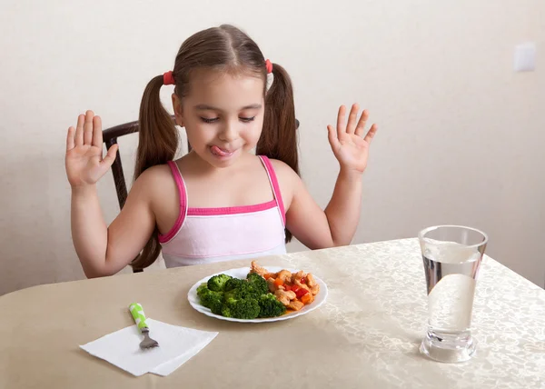 Happy girl licks lips, looking at the dish with meat and broccoli — Stock Image Happy girl licks lips, looking at the dish with meat and broccoli Stock Picture