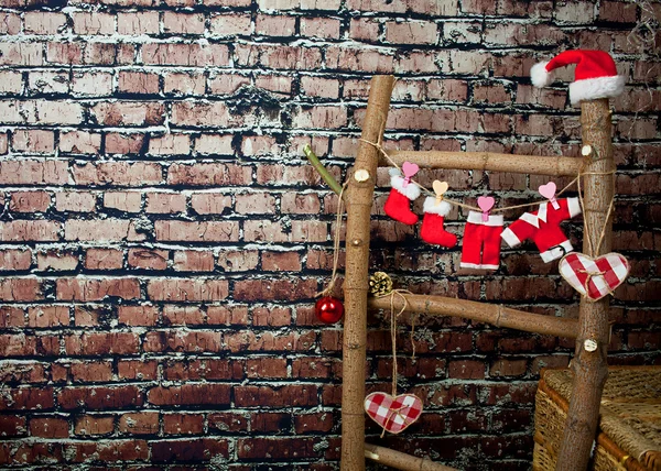 Деревянная лестница с миниатюрной одеждой Санта Клауса, стоящего у кирпичной стены — стоковое фото