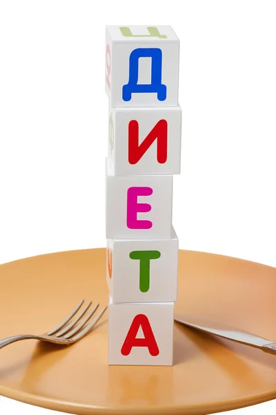 "饮食"是一个俄语单词，由立方体在盘子上用叉子和刀 — 图库照片