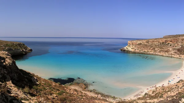 Puhdas kiteinen vedenpinta saaren ympärillä (Lampedusa ) — kuvapankkivalokuva