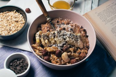 Bir kase yulaf lapası, muz ve fındıklı. Üst Manzara. Sağlıklı vejetaryen kahvaltısı