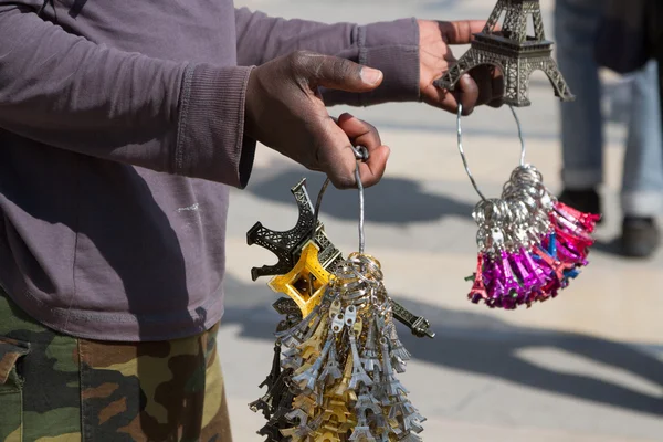 Inmigrante africano ofreciendo souvenirs frente al Palacio de Versalles — Foto de Stock