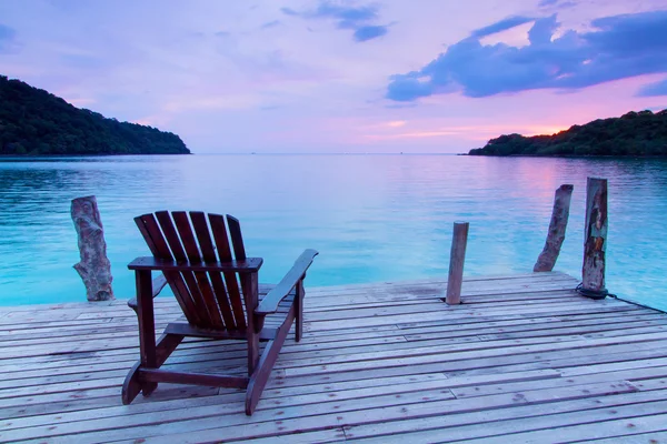 Osamělý scéna; Jediná dřevěné židle v přístavu nad mořem na twili — Stock fotografie