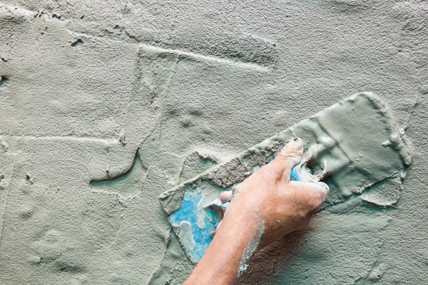 Closeup mason hand spreading fresh concrete mix with trowel — Stock Photo, Image