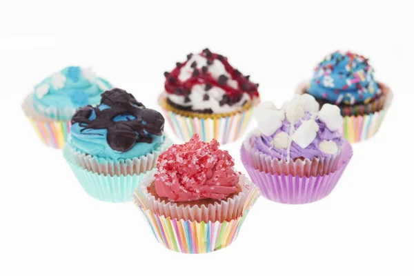 Grupo de seis diferentes Cupcakes de colores aislados Imagen de archivo