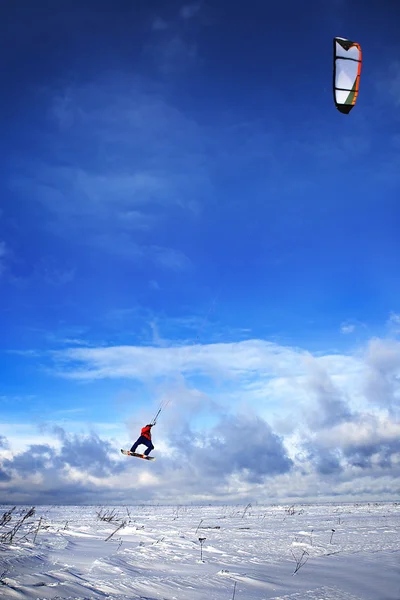 Snowkiting 人在船上跳到天空 免版税图库图片