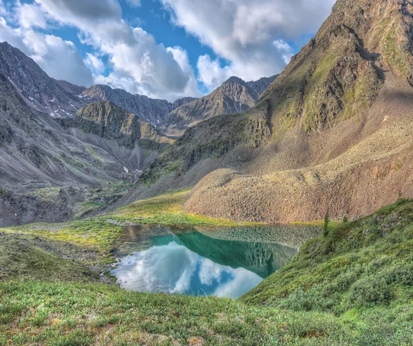The picturesque lake in a small valley below the mountain peak — Stock Photo, Image